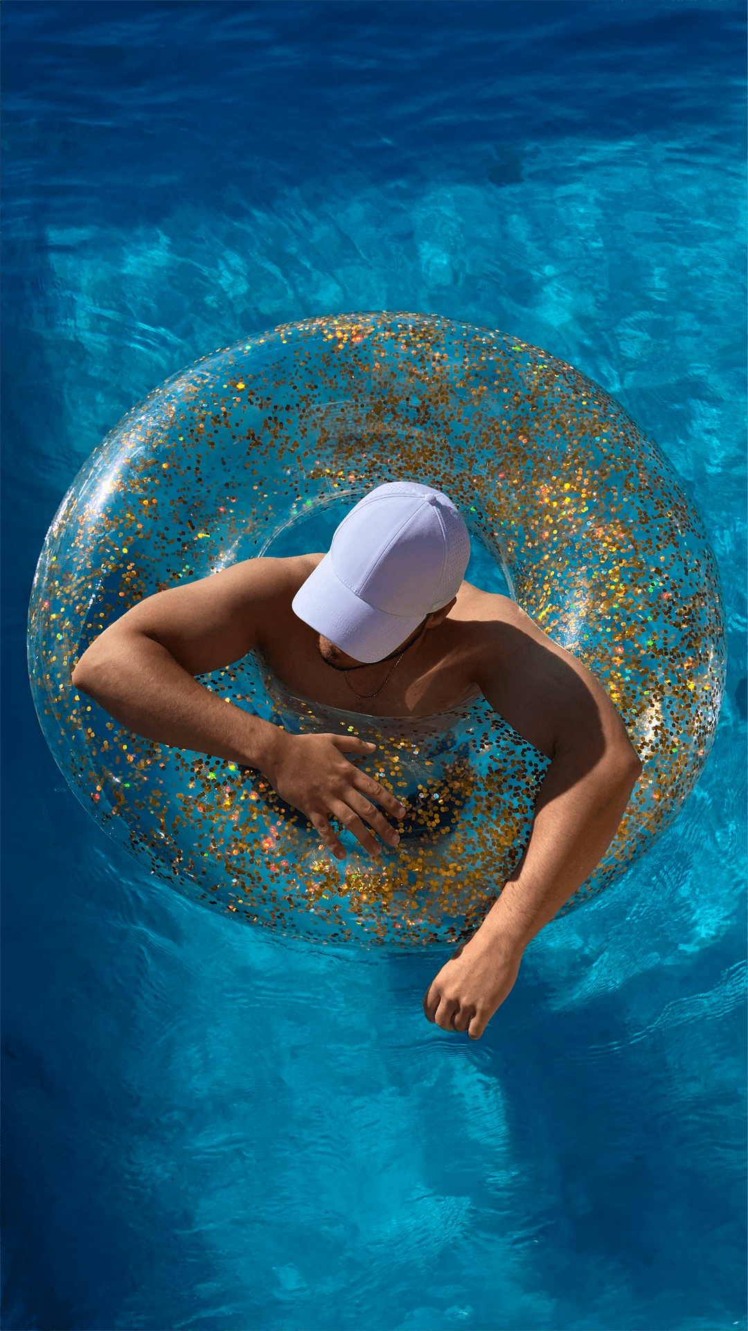 Mann aus Vogelperspektive schwimmt mit apol Cap in Schwimmreif in Pool